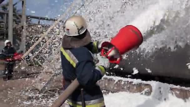 Bombeiro extingue um incêndio em uma instalação de armazenamento de óleo com espuma
 - Filmagem, Vídeo