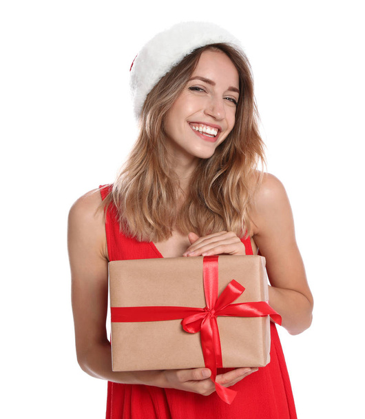 Happy young woman in Santa hat with gift box on white background. Christmas celebration - Valokuva, kuva