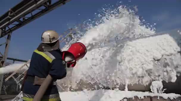 Kőolajtermék alapú tűzoltás. Fireman kioltja a tüzet habbal - Felvétel, videó
