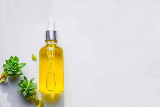 Serum mit natürlichem Vitamin C, kosmetisches Öl in einer Glasflasche mit Pipette. Kleiner Hintergrund - Foto, Bild