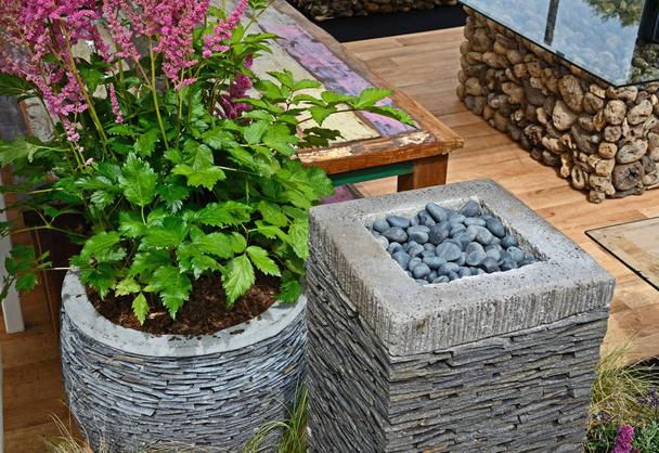 Garden detail of a craft made slate containers with flowering  Astilbe, plants and pebbles - Photo, Image