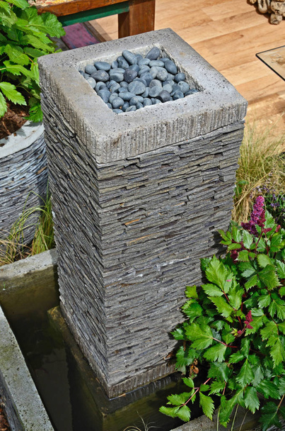 Garden detail of a craft made slate container with flowering plants and pebbles - Photo, Image