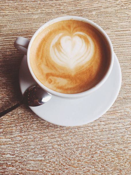 Чашка гарячого капучино в кафетерії, кава на дерев'яному столі
 - Фото, зображення