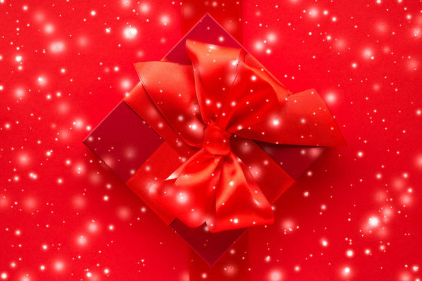 Téli üdülési ajándékok és ragyogó hó piros háttérrel, christm - Fotó, kép