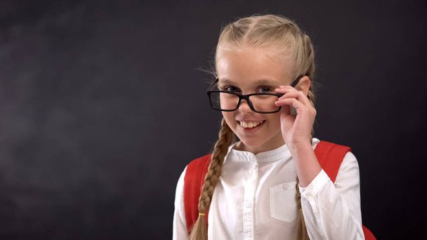 Playful pupil looking through eyeglasses at camera, love to school, education - Photo, image