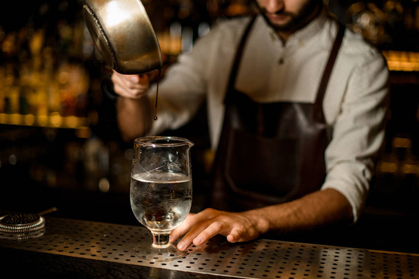 Professional bartender pouring a hot melting caramel to the measuring glass cup to cool - Φωτογραφία, εικόνα