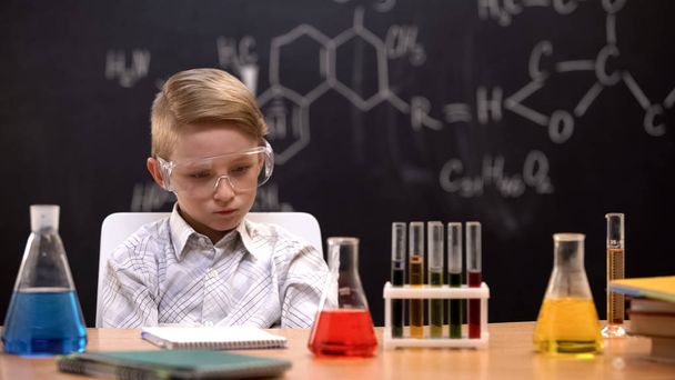 Sad boy thinking about new scientific experiments during chemistry lesson - Valokuva, kuva