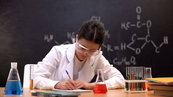 Chemistry experimenter writing down results of scientific researches in lab - Fotó, kép