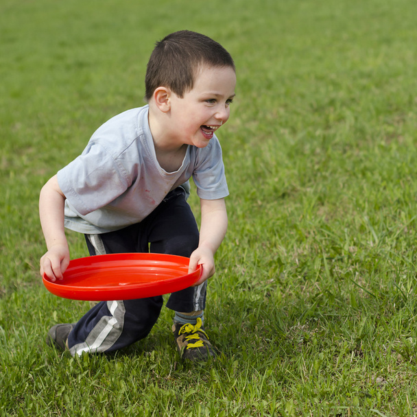 Criança brincando com frisbee
 - Foto, Imagem