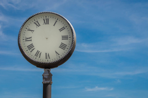 Абстрактні старомодний годинник вулиці з римськими цифрами без стрілок на синьому тлі неба. Поняття зупиненого часу - Фото, зображення