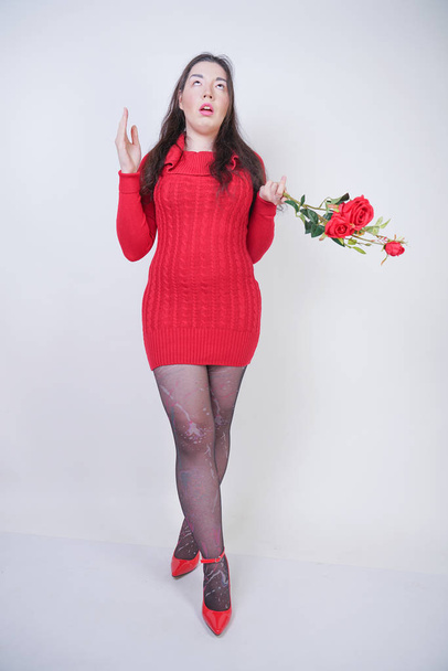 симпатичная девушка plus size в элегантном красном платье с цветами на белом студийном фоне
 - Фото, изображение