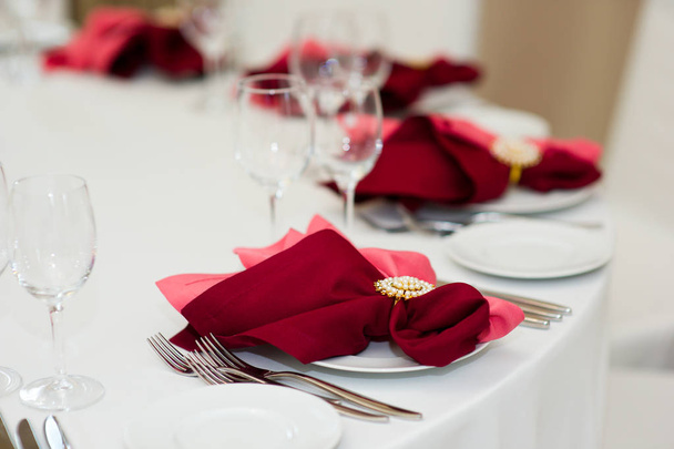 a place at the table served with a red napkin - 写真・画像