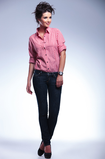 Случайная молодая женщина в джинсах и красной рубашке смотрит в сторону
 - Фото, изображение