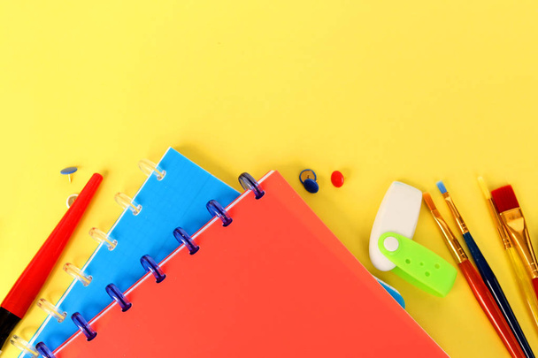 notebooks, pens, felt-tip pens and other stationery on a bright background; school concept, close-up, copy space - Photo, Image
