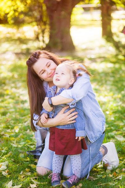 Młoda matka w ciąży gra z jej małą córką w jesiennym parku. Szczęśliwy macierzyństwo. Szczęśliwa zdrowa Ciąża - Zdjęcie, obraz