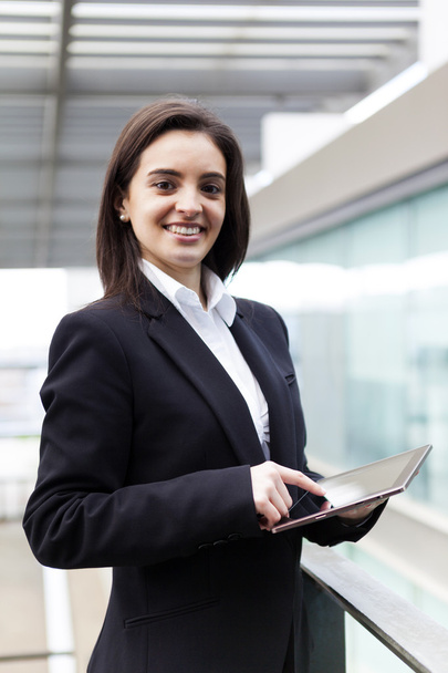Business woman standing with a tablet in her hands at the office - Foto, afbeelding