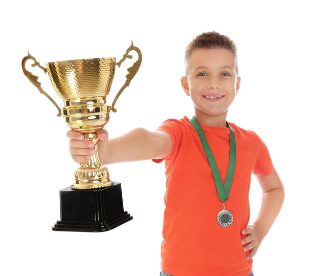 Happy boy with golden winning cup and medal isolated on white - Valokuva, kuva