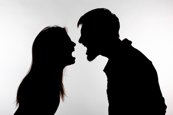 Concetto di aggressione e abuso - uomo e donna che esprimono violenza domestica nella silhouette dello studio isolati su sfondo bianco
. - Foto, immagini