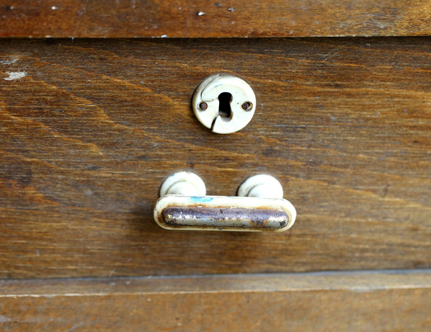 Metal handle and keyhole of an old wooden table. - Photo, Image