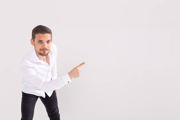 Handsome man with beard pointing in one direction on a white background, copyspace - Photo, Image