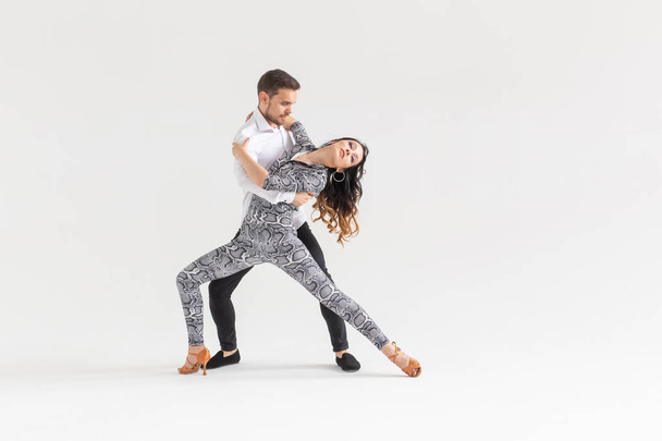 Couple passionné dansant danse sociale kizomba ou bachata ou semba ou taraxia sur fond blanc avec espace de copie
 - Photo, image