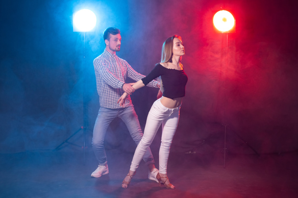 Concepto de baile social, kizomba, salsa y semba - joven hermosa pareja bailando bachata o salsa en la oscuridad
 - Foto, Imagen