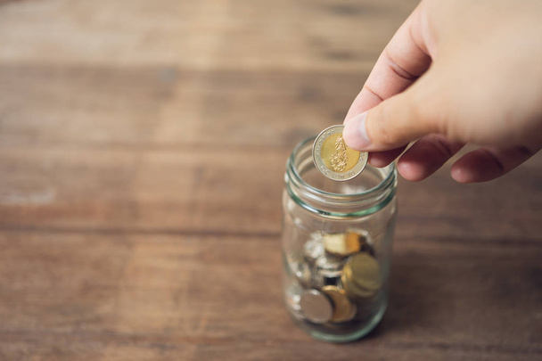 Geschäftsleute legen die Münze in ein Glas, um Geld zu sparen, sparen mon - Foto, Bild