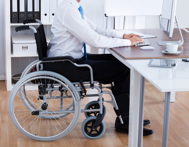 Businessman Sitting On Wheelchair And Using Computer - Фото, зображення