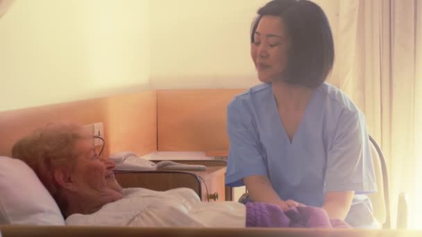 beeldmateriaal van verpleegster verzorgen van oudere vrouw in bejaardentehuis - Video