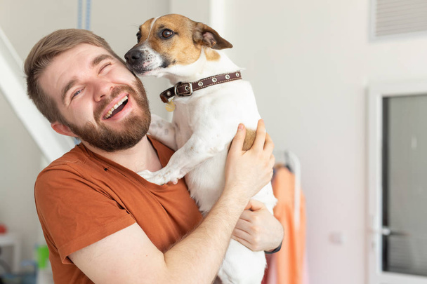 Eläin, lemmikki ja ihmiset käsite Hymyilevä mies rento sinappi t-paita hänen jack russell terrieri
 - Valokuva, kuva