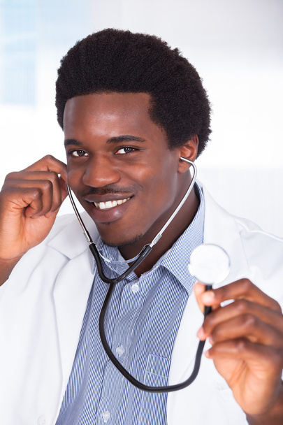 Happy Doctor With Stethoscope Sitting At A Desk - Foto, imagen