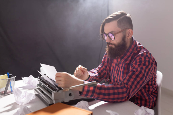 Concept de personnes et de technologie - Journée mondiale de l'écrivain, bel homme avec des lunettes, vêtu d'une chemise à carreaux, travaillant sur la machine à écrire
 - Photo, image