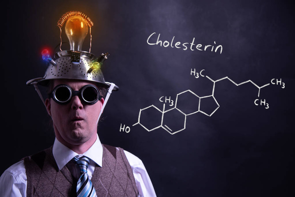 Nerd presentando fórmula química dibujada a mano de Colesterol
 - Foto, Imagen