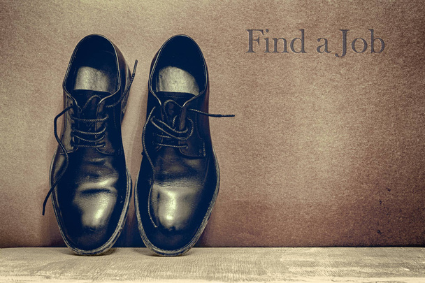 Find a Jobt on brown board and work shoes on wooden floor - Photo, Image