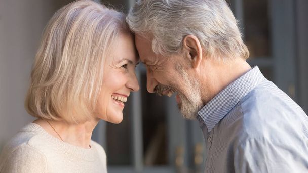 Happy mature couple touch foreheads enjoying romantic moment - Photo, Image