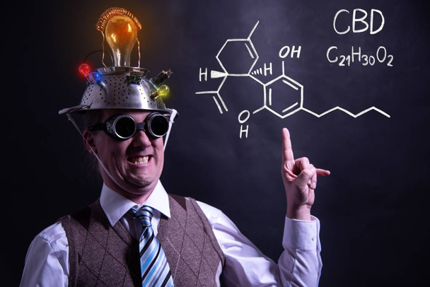 Nerd presentando fórmula química dibujada a mano de CBD
 - Foto, Imagen