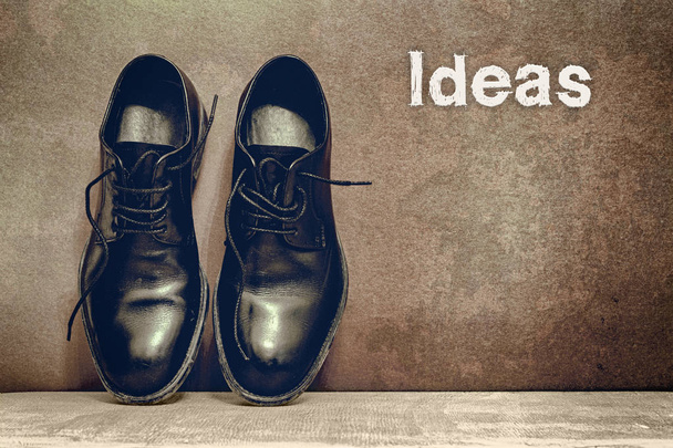 Идеи на коричневой доске и рабочая обувь на деревянном полу
 - Фото, изображение