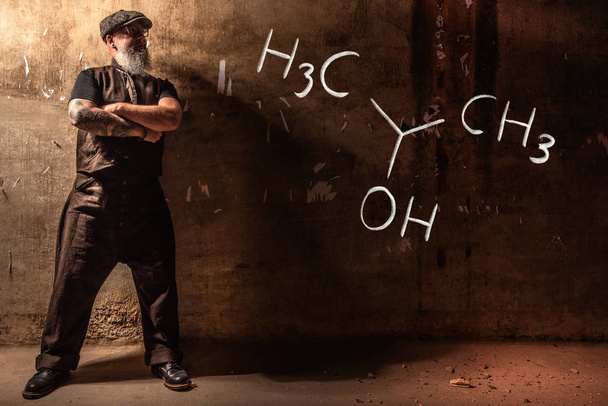 Parrakas vanha mies esittelee Isopropyylialkoholi-isopropanolin 2-propanolin käsintehtyä kemiallista kaavaa
 - Valokuva, kuva