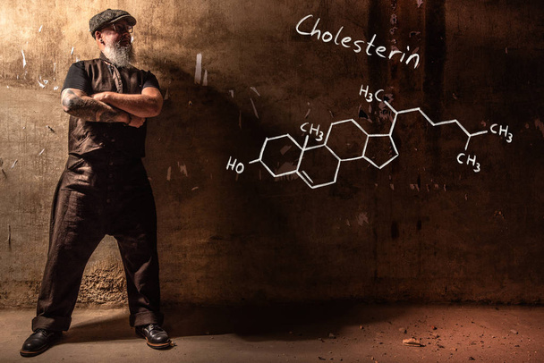 Bearded old man presenting handdrawn chemical formula of Cholesterol - Photo, Image