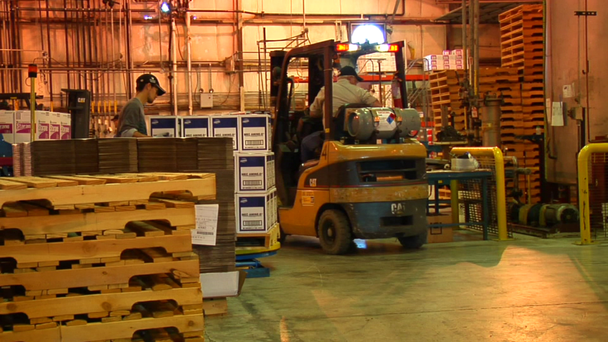 Busy industrial warehouse with two forklifts and pallets - Footage, Video