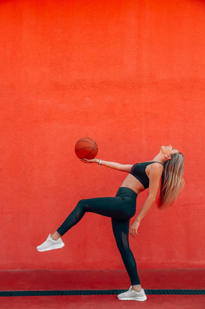 Young woman with fit body playing basketball and having fun on court. Sunny day. - Foto, Imagem