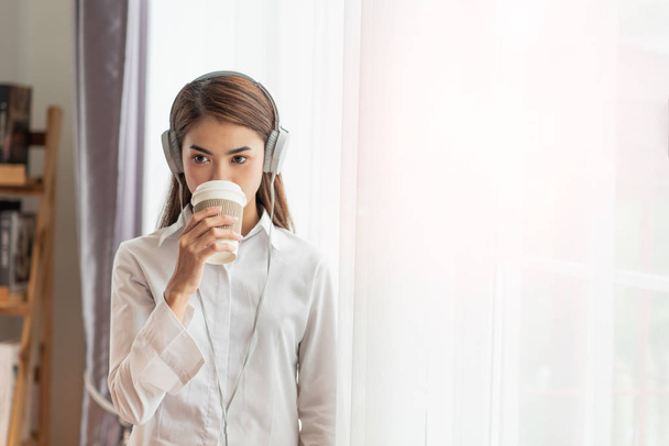 Young Asian woman enjoy listening to music with headphones and h - Foto, afbeelding