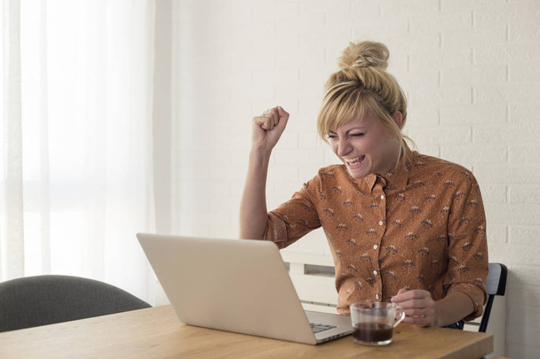 Feliz mujer emocionada animando satisfecho con los resultados en el ordenador portátil
. - Foto, imagen
