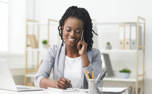 Pozytywny biznes Lady HAVING rozmowa telefoniczna biorąc notatki w biurze - Zdjęcie, obraz
