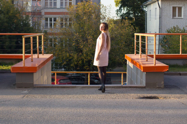 a young girl in a white dress on the background of urban buildings - Valokuva, kuva