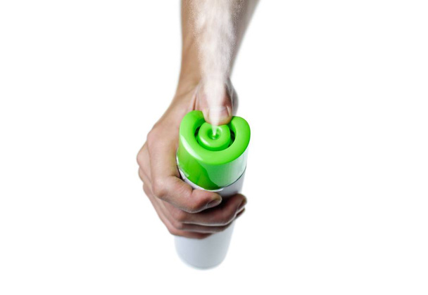 Ręczne trzymanie zielonego odświeżacza powietrza. Z bliska. Izolowane na białym ba - Zdjęcie, obraz