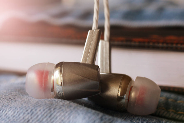 Silver headphones on jeans so close - Fotoğraf, Görsel