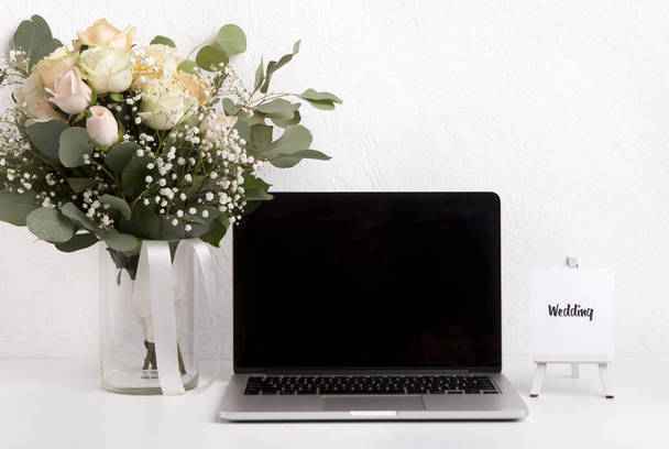 Γυναίκα γραφείο στο σπίτι με φορητό υπολογιστή και τριαντάφυλλα ανθοδέσμη - Φωτογραφία, εικόνα