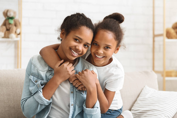 Schattige Afro-Amerikaanse meisjes omarmen thuis - Foto, afbeelding