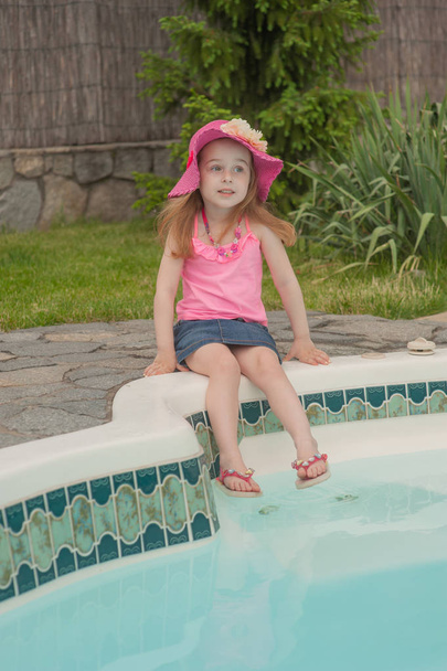 Child girl resting near the pool. - Photo, Image